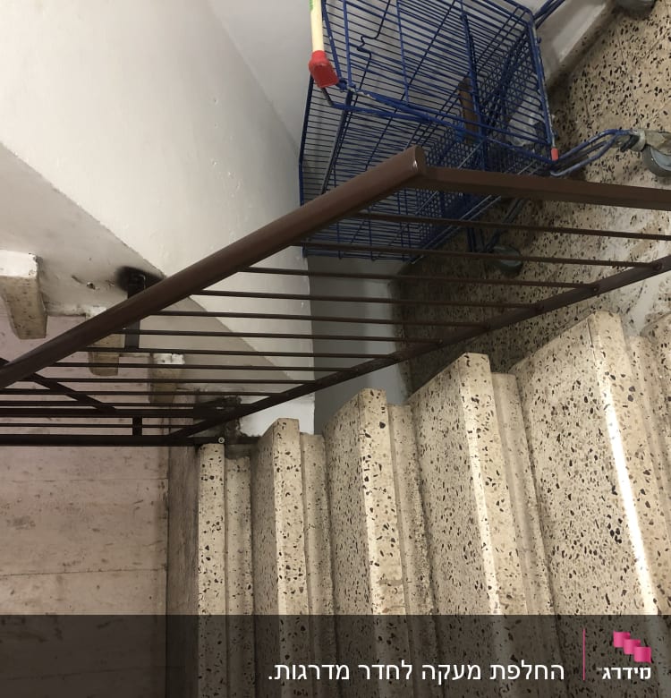 מעקה מתכת חום ליד מדרגות אבן
